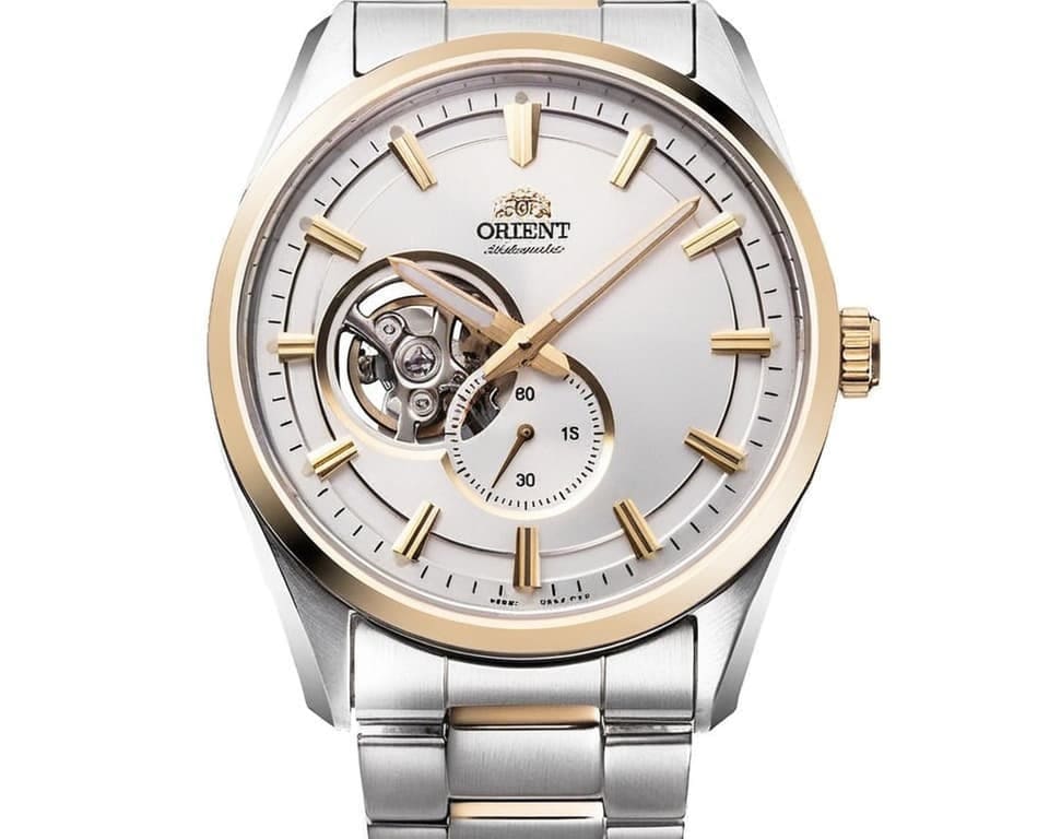 Orient automatic watch featuring open heart display, white dial with gold accents, and two-tone stainless steel bracelet