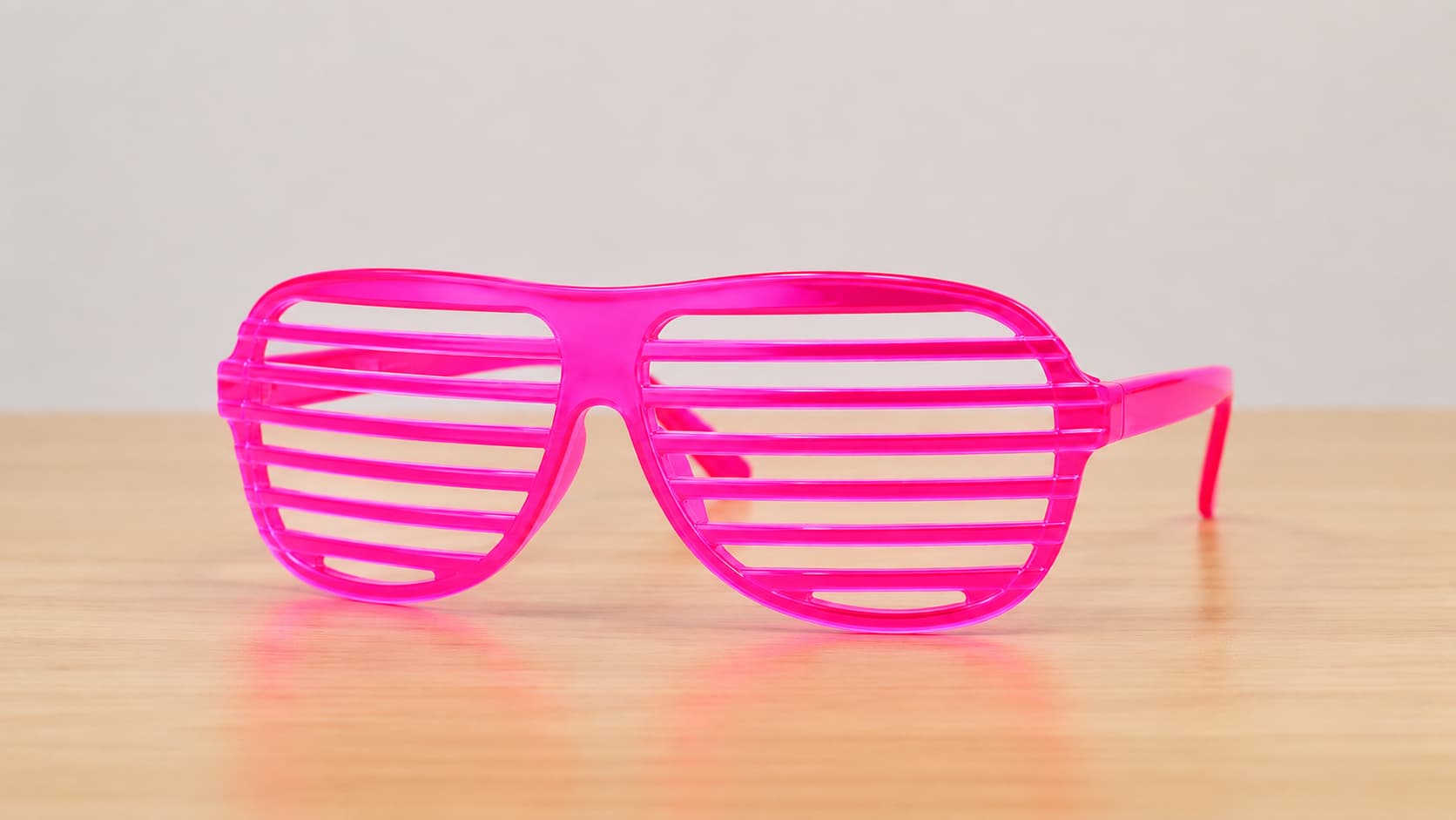 Close-up of a single pink shutter shades sunglasses with horizontal slats instead of lenses