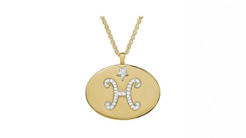 Gold oval Pisces coin pendant with diamond-outlined H symbol and star accent