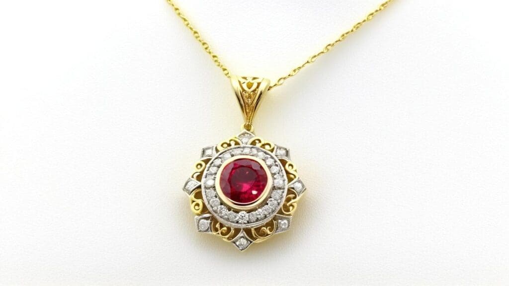Red spinel pendant necklace with ornate gold and diamond-studded design on white background