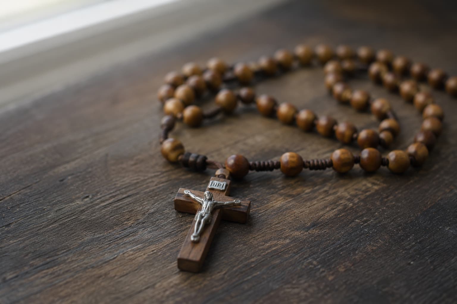 Close-up of a wooden rosary crucifix with INRI inscription