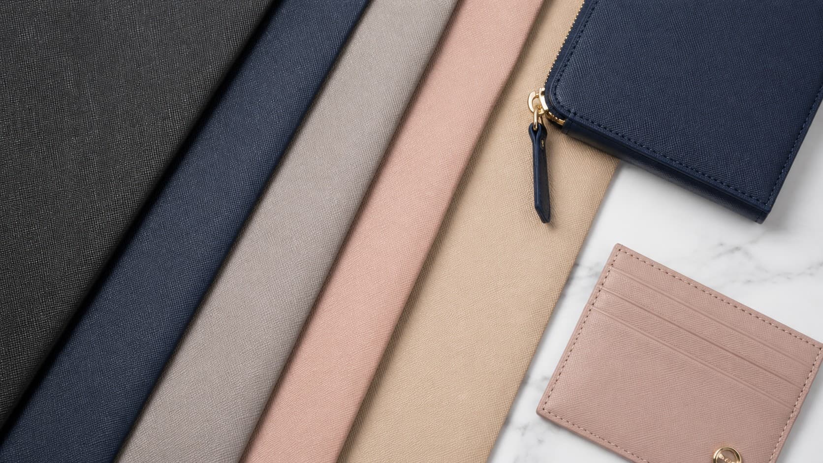 Navy saffiano leather zip wallet and pink cardholder showing the crosshatch pattern and stitching detail