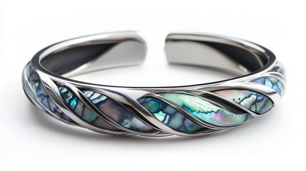 Stylish silver cuff bracelet featuring abalone shell inlay with an elegant twisted design, reflecting modern jewelry aesthetics.