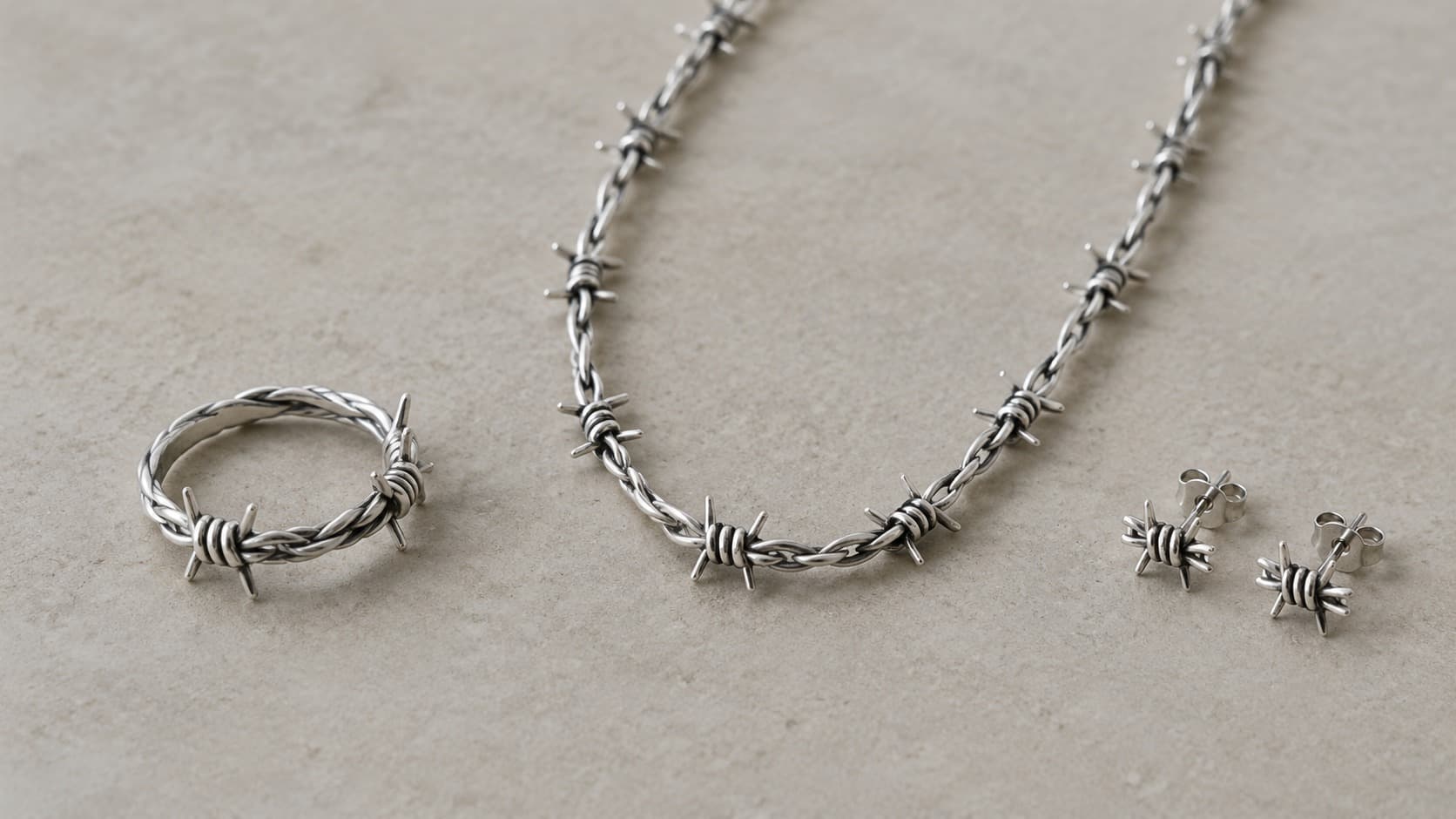 Silver barbed wire jewelry set with ring, necklace, and stud earrings