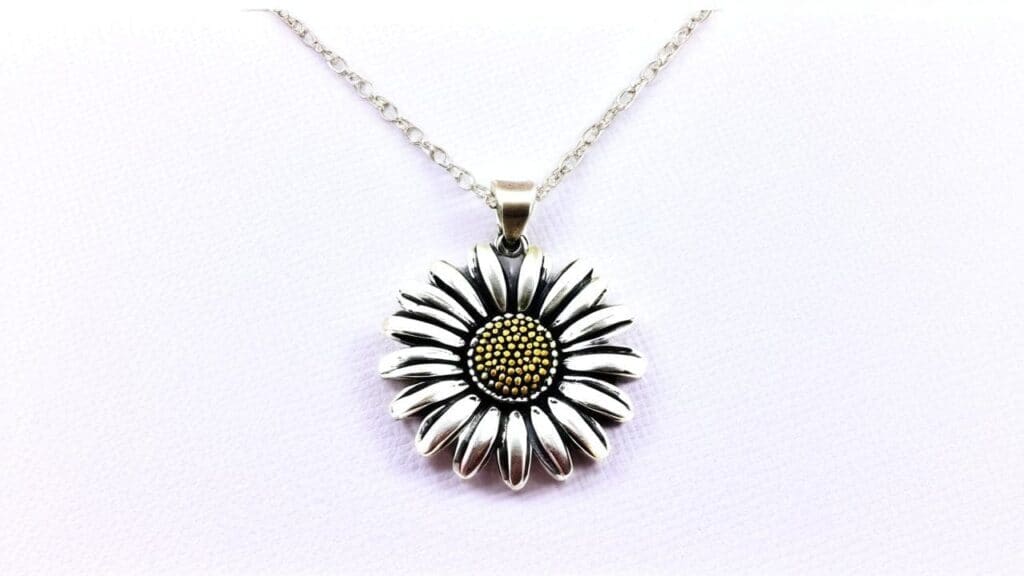 Sterling silver daisy pendant necklace featuring detailed petals and golden center on delicate chain