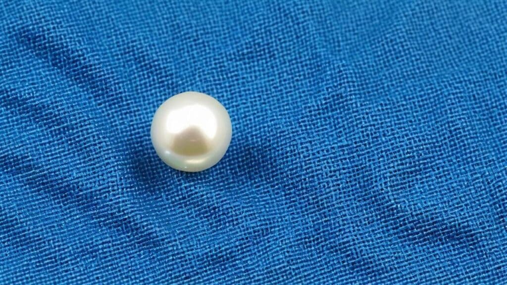 Close-up of a single bleached pearl showing its smooth, lustrous surface and improved color uniformity.