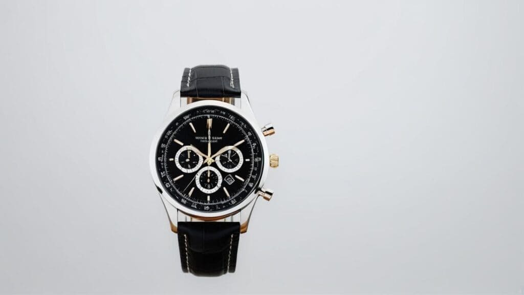 Luxury sports chronograph watch featuring black dial, stainless steel case with gold accents, and black leather strap