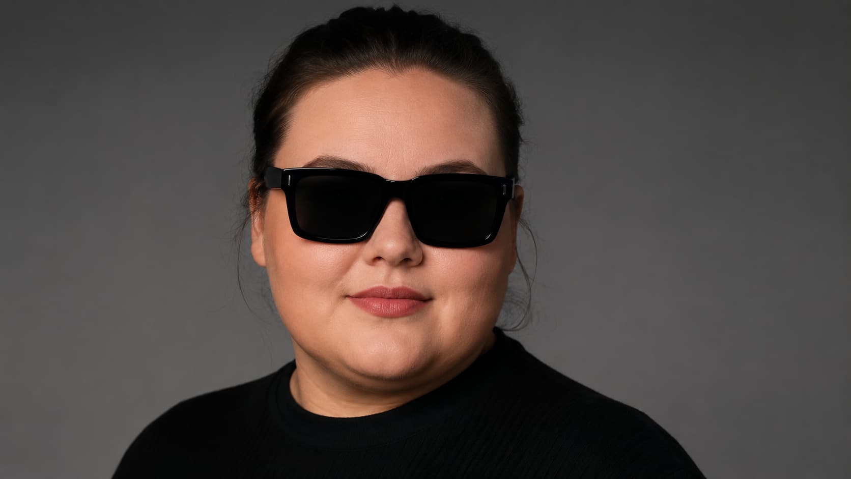 Woman with a round face wearing square black sunglasses