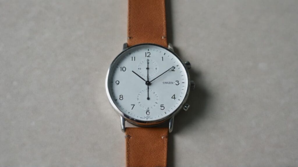 Stainless steel watch case with brown leather strap demonstrating different watch material combinations