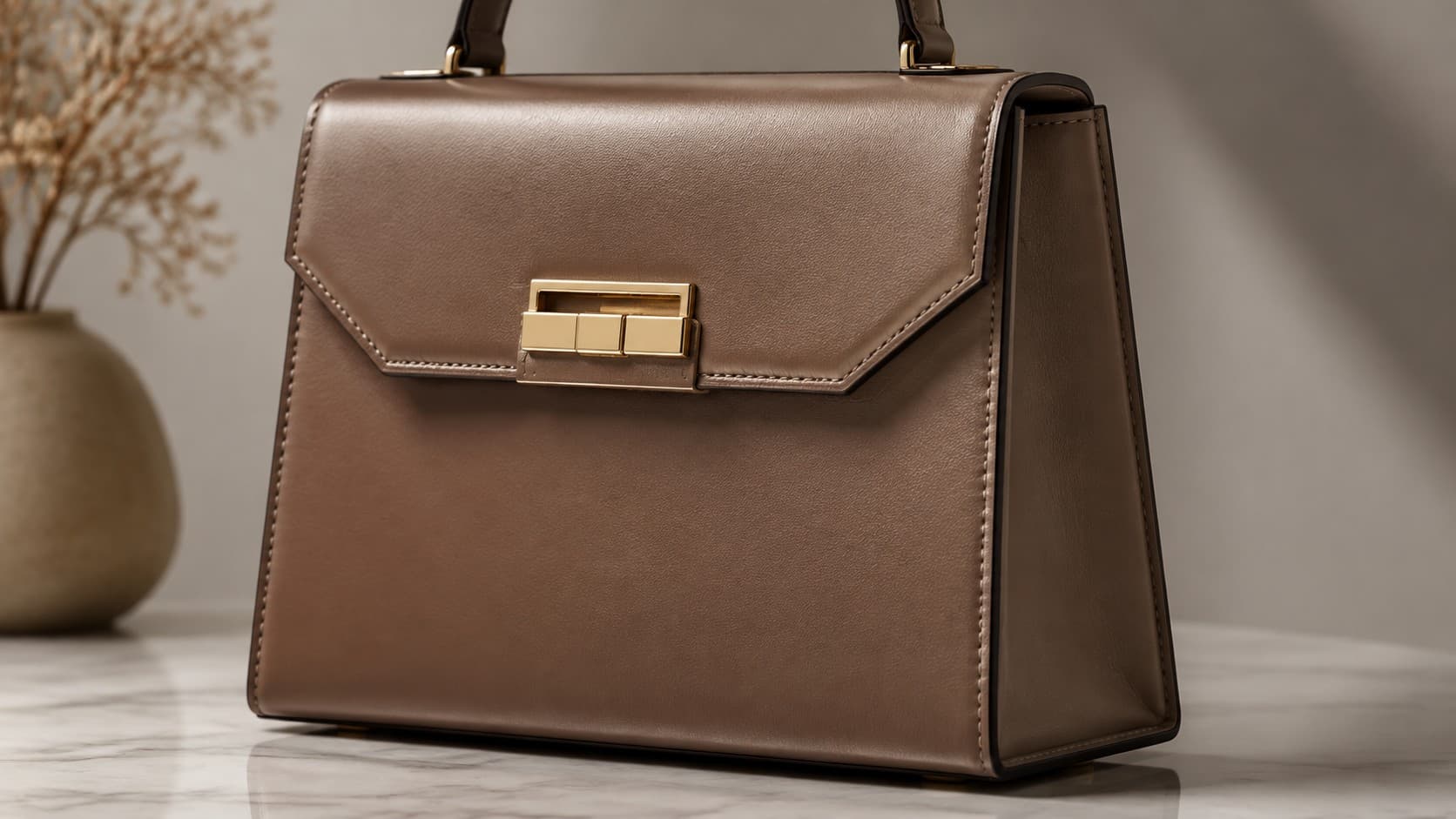 Structured brown leather handbag with sharp edges and gold hardware