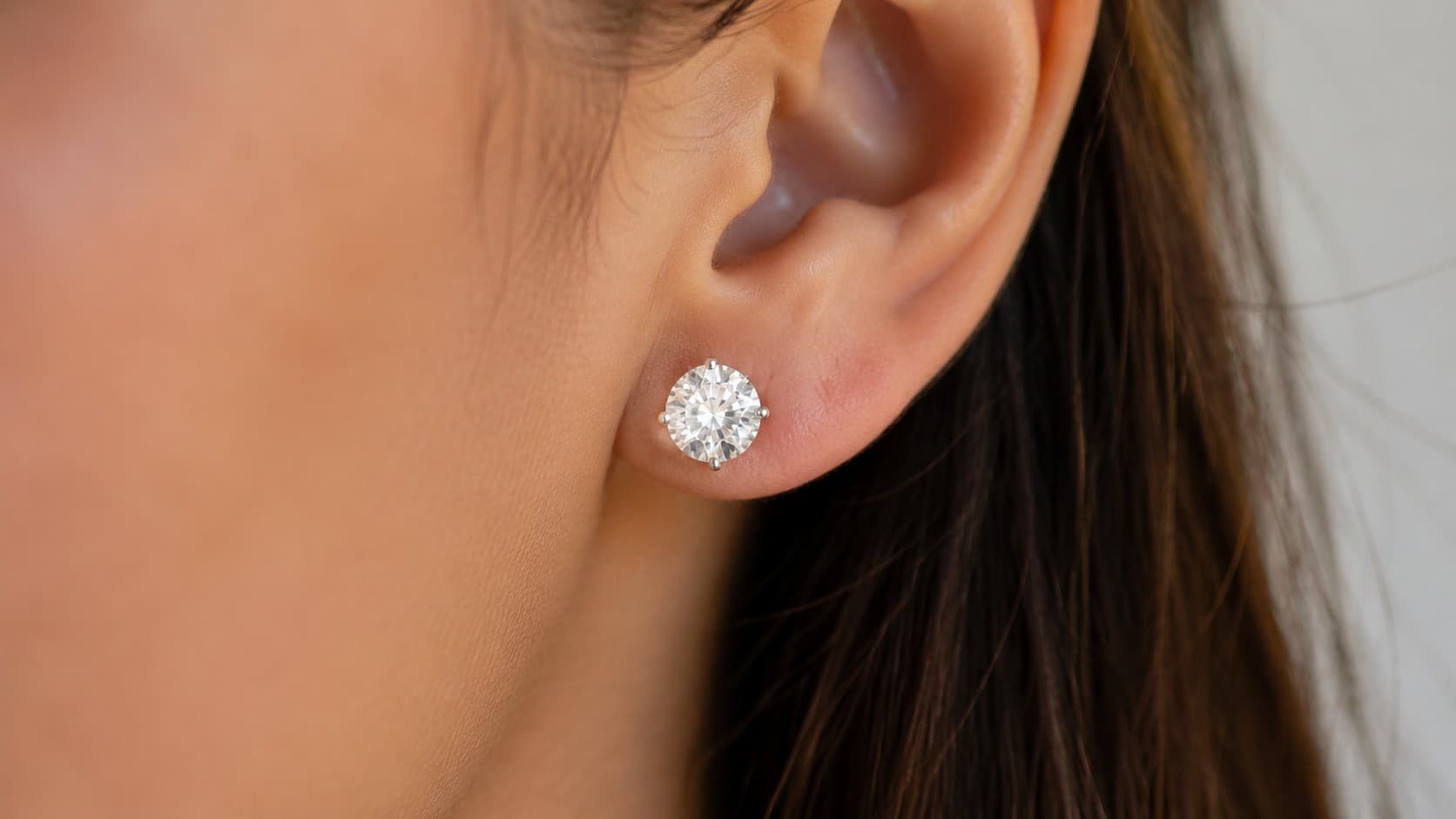 Diamond stud earring worn on a woman's earlobe