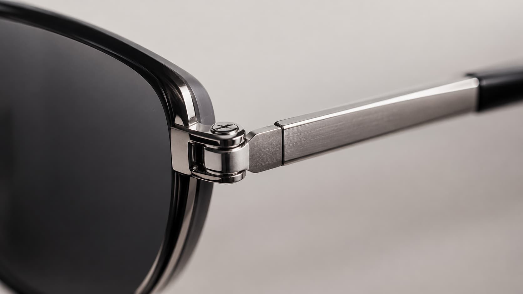 Close-up of a sunglasses frame hinge and metal temple arm