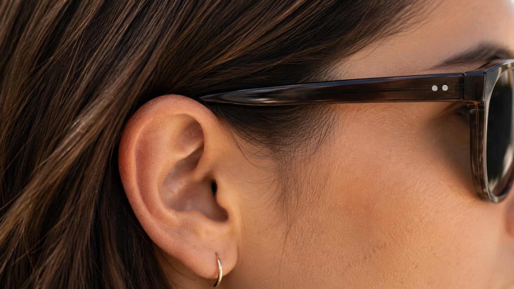 Close-up of a sunglasses temple arm resting comfortably behind the ear