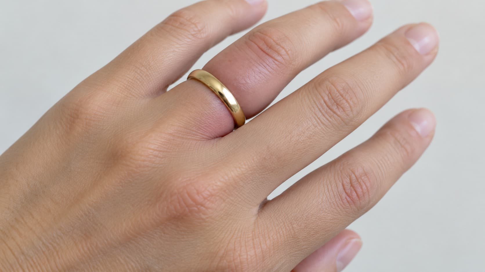 Close-up of a swollen finger with a tight gold ring