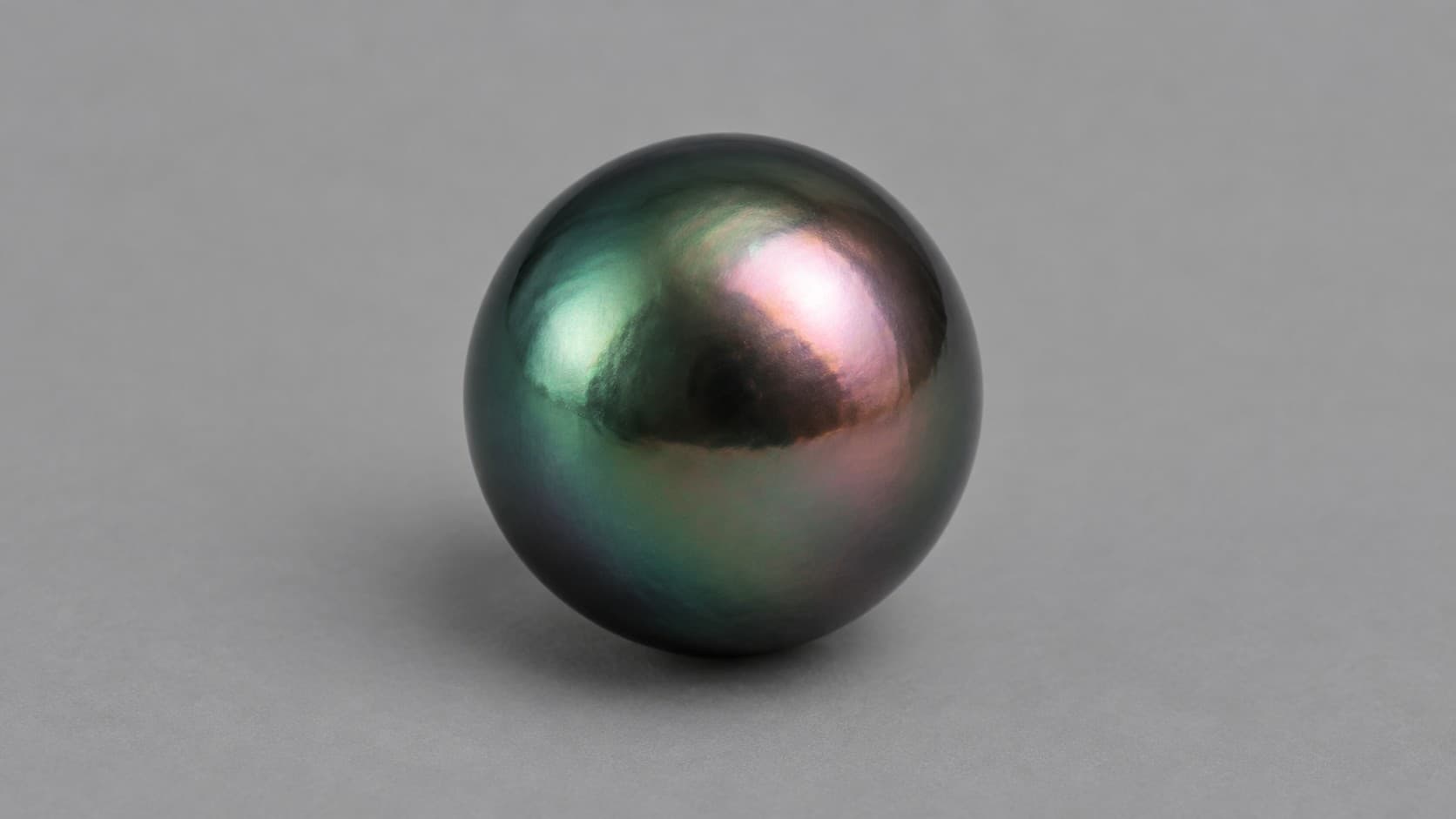 Black and peacock Tahitian pearl with green and rose overtones