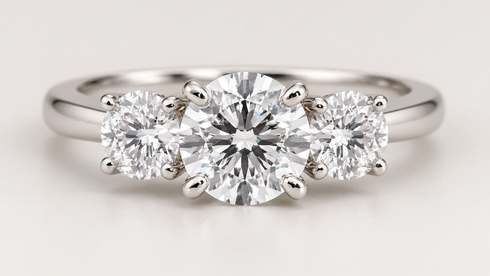 White gold three-stone diamond ring with a round center diamond and two matching side diamonds