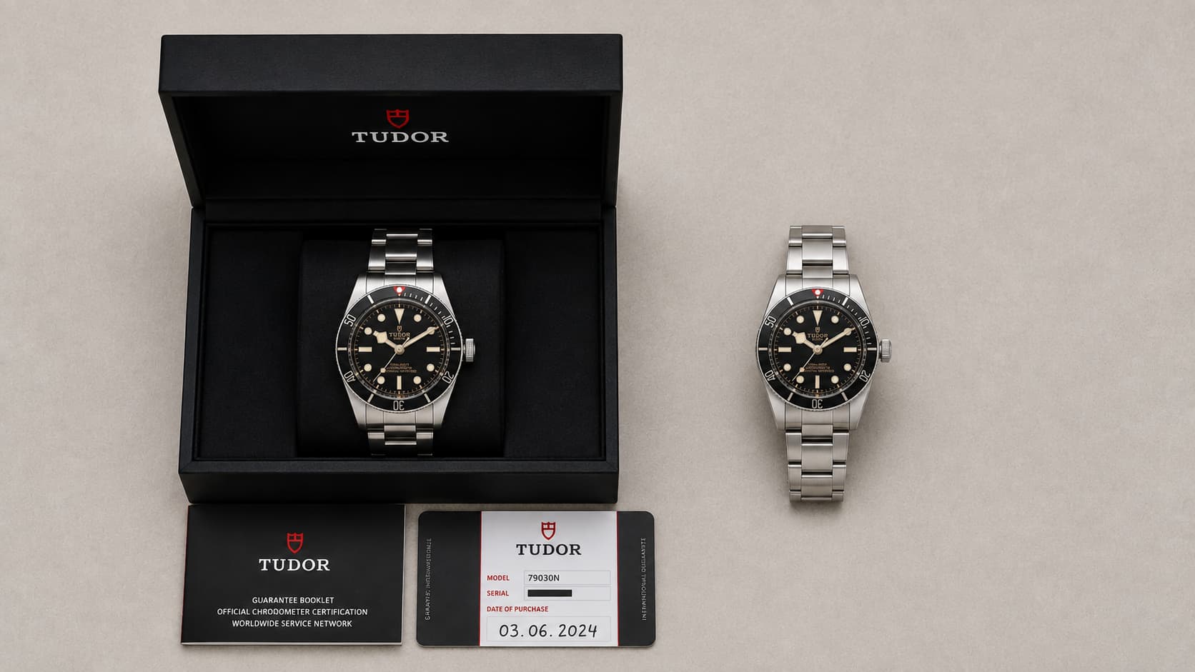 Tudor Black Bay watch with its open presentation box, guarantee booklet, and warranty card