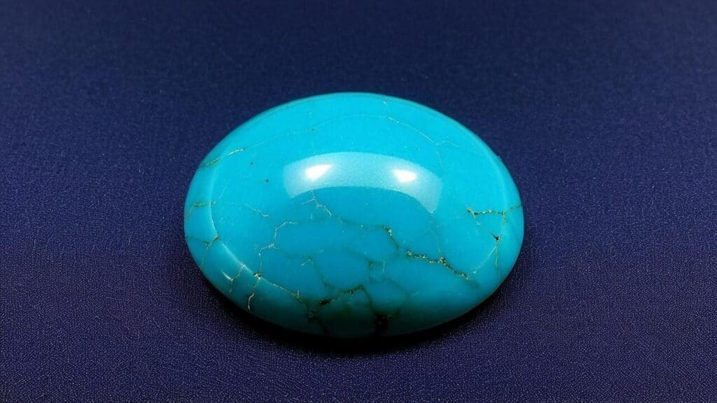 Vibrant turquoise cabochon featuring natural matrix pattern and glossy finish