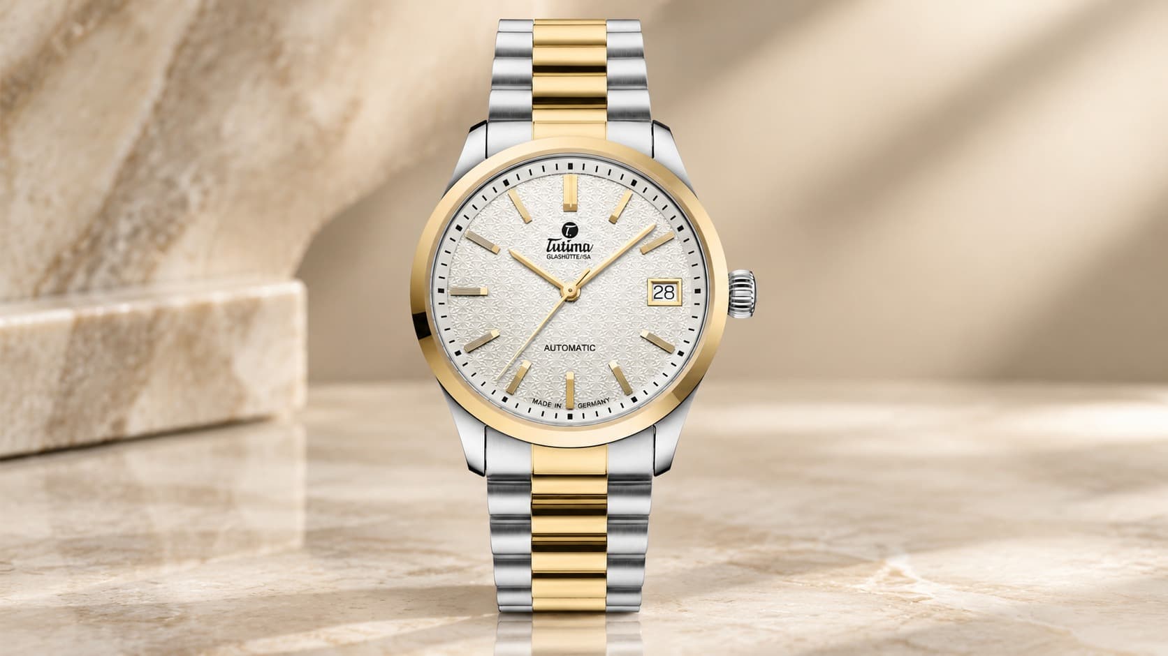 Tutima Glashütte Sky 6705-22 two-tone steel and gold automatic watch with white textured dial on a marble background