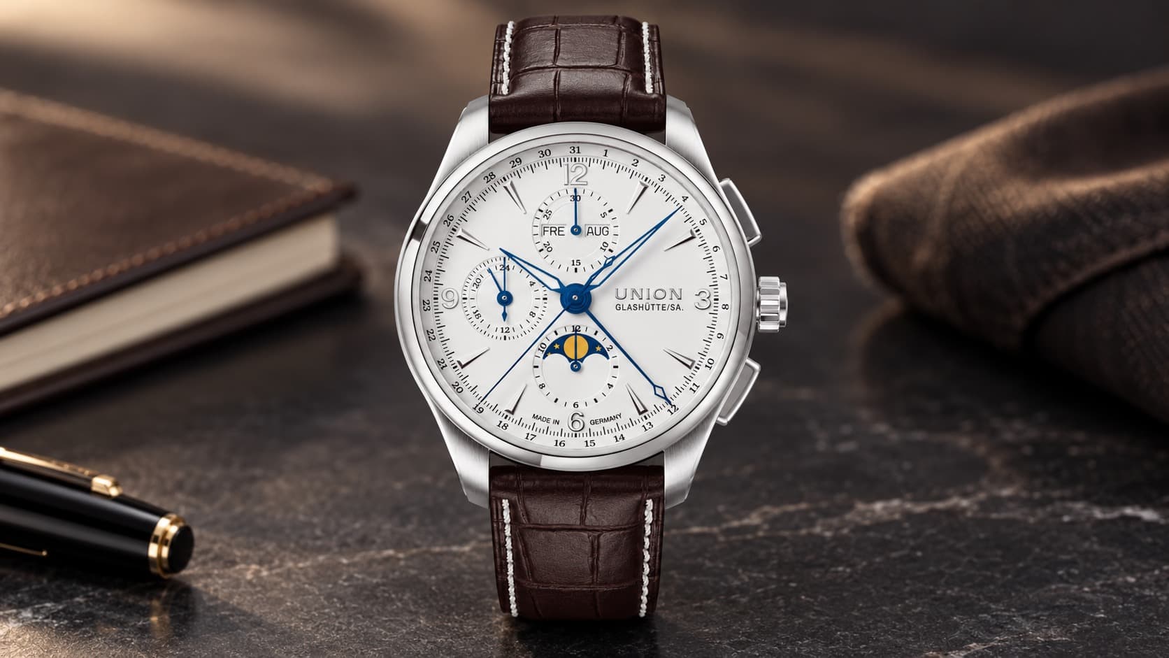 Union Glashütte Belisar Chronograph Moon Phase watch with blue hands, white dial, and brown alligator-pattern leather strap