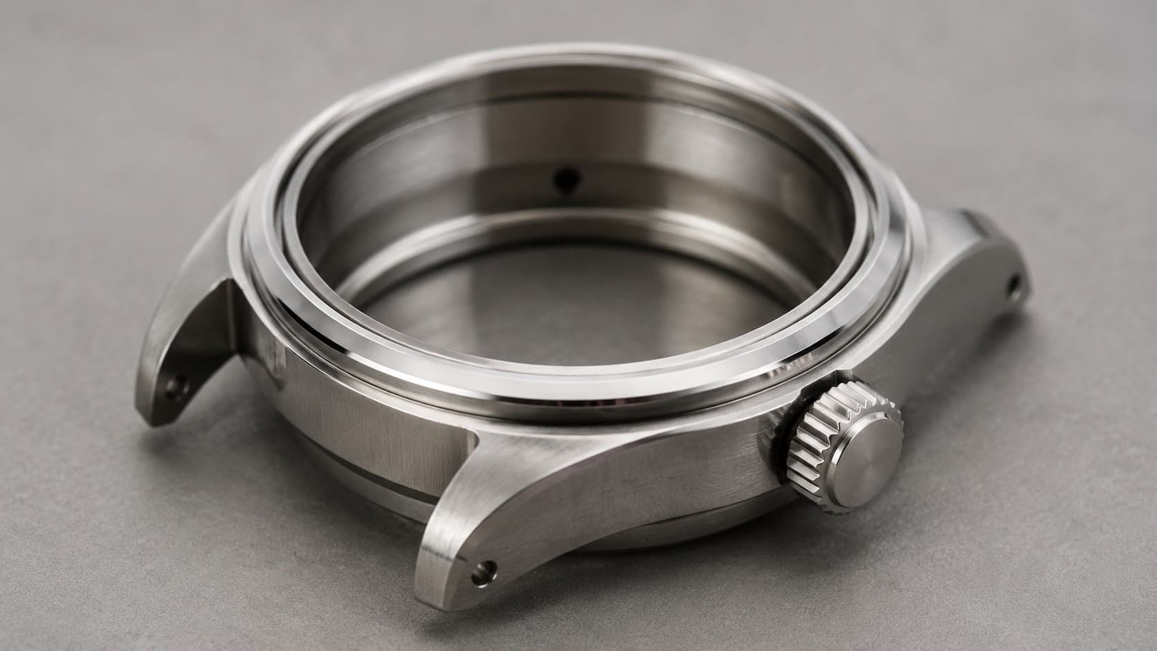 Stainless steel watch case with lugs and crown, dial removed