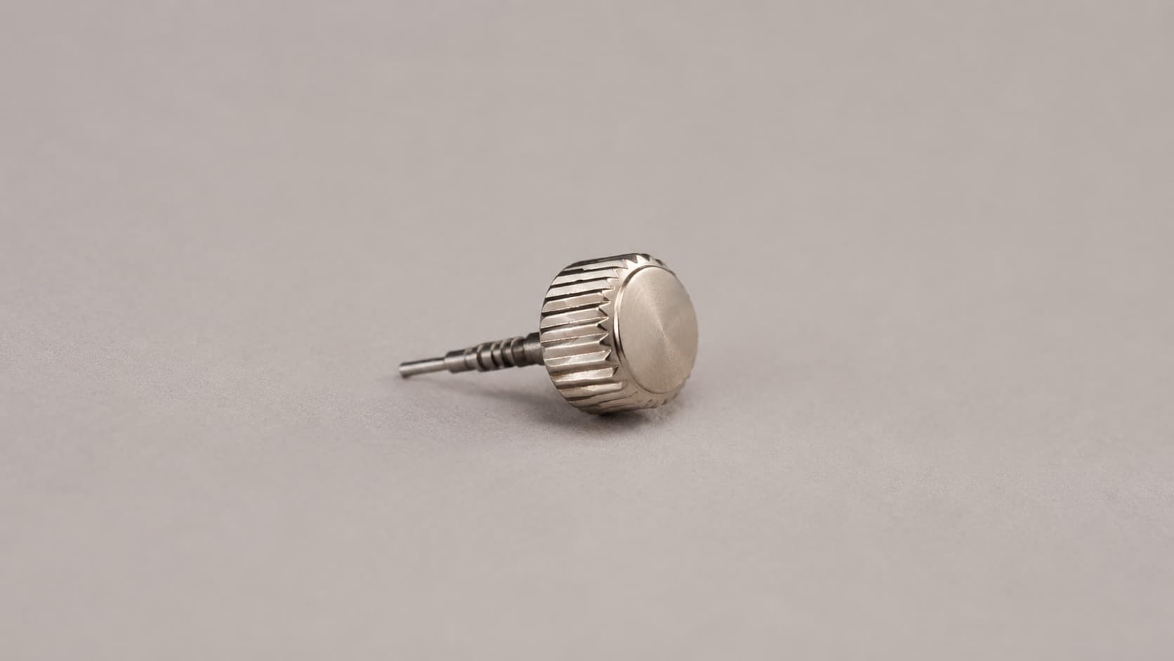 Watch crown with fluted grip and stem, removed from case