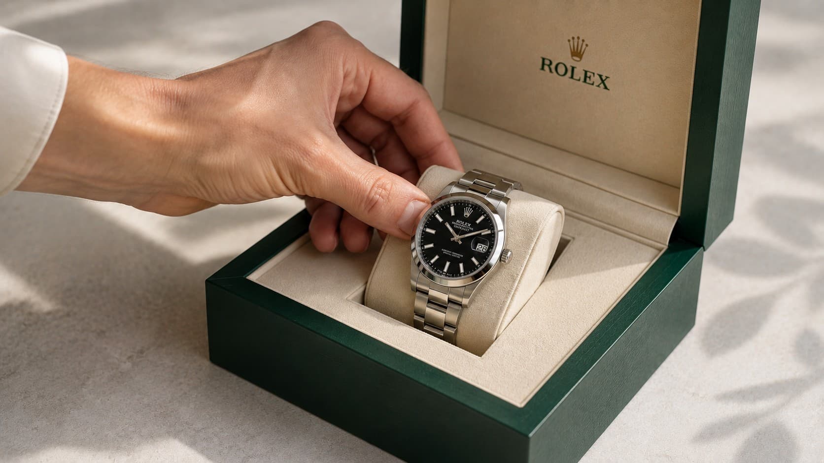 Close-up of a hand placing a watch back into its presentation box