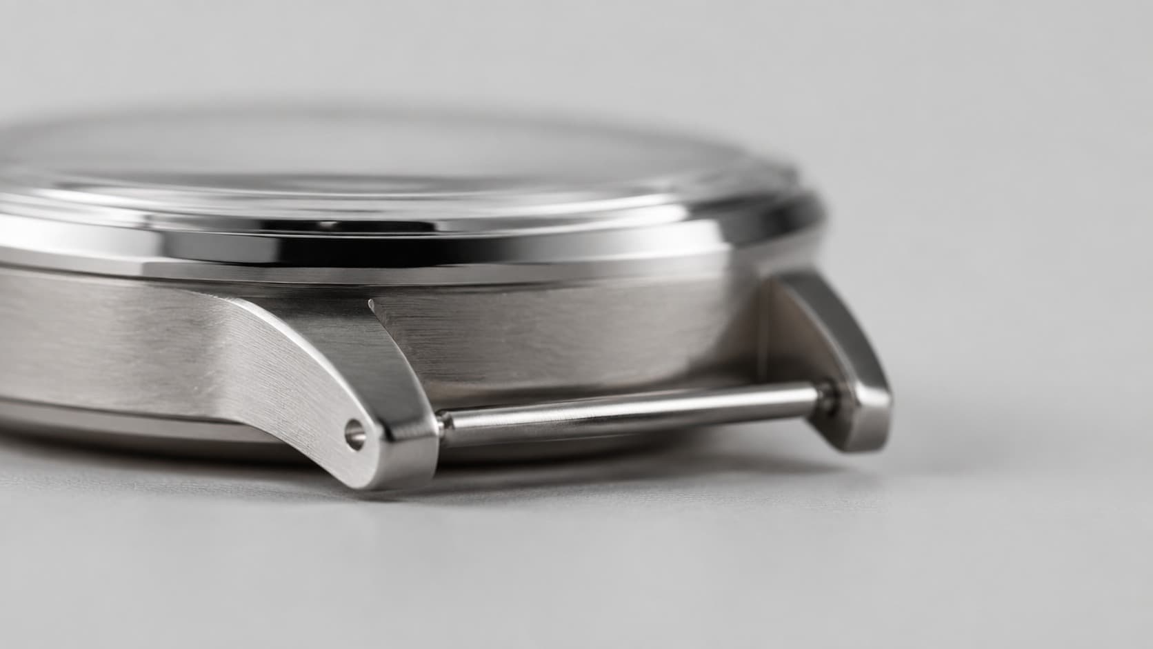 Close-up of watch case lugs with strap and spring bar attached