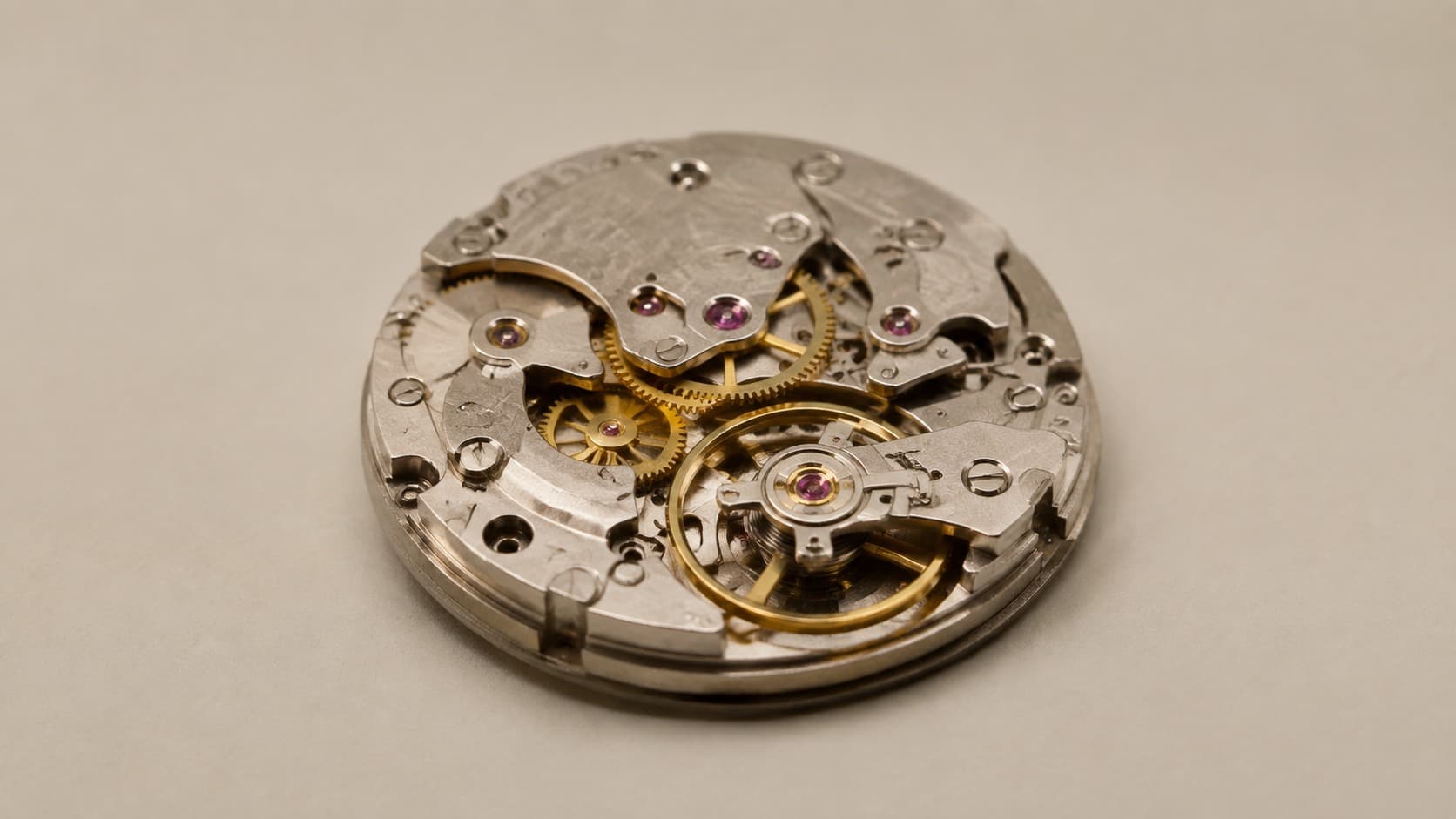 Mechanical watch movement showing gears and jeweled balance wheel