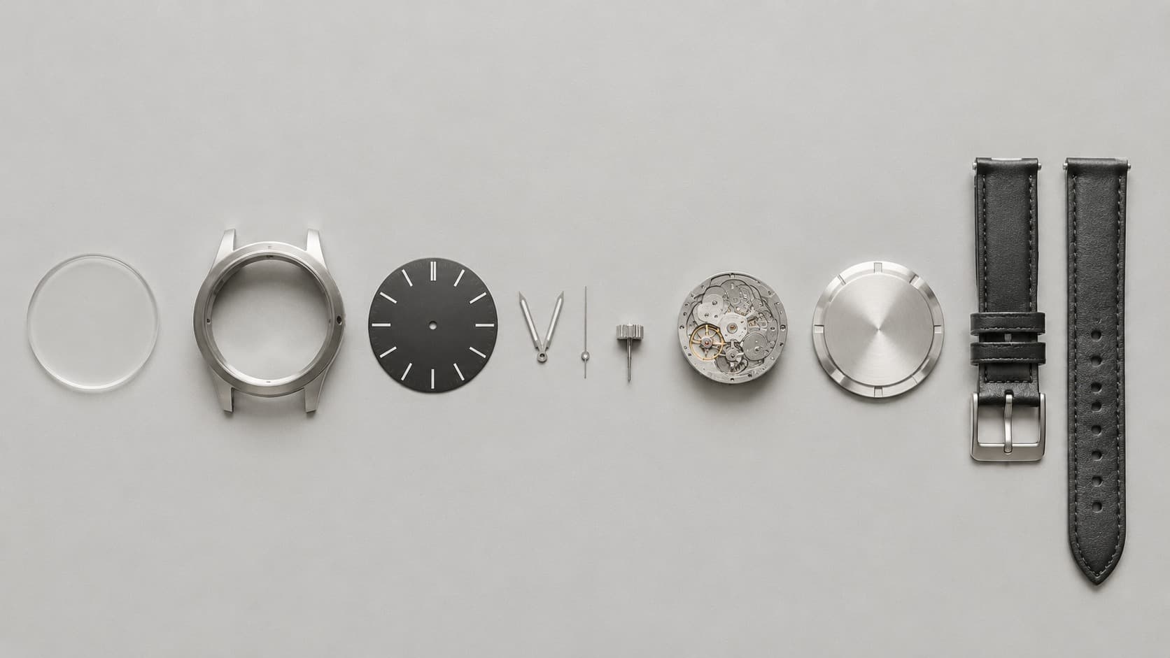 Exploded view of a wristwatch showing all its individual parts laid out