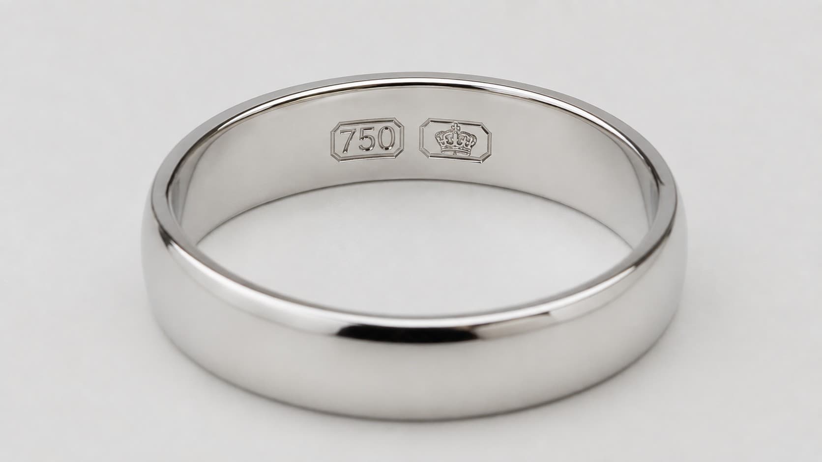 Close-up of a 750 gold stamp and crown hallmark engraved inside a white gold ring band