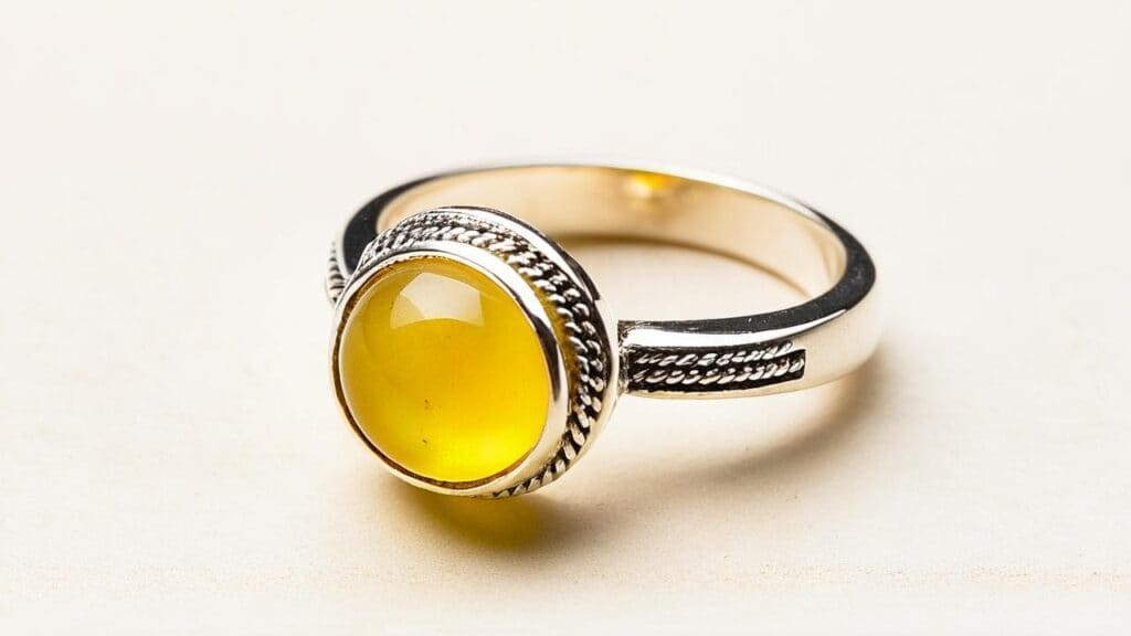 Yellow copal gemstone set in a handcrafted silver ring, highlighting the warm hue and smooth polish of natural resin