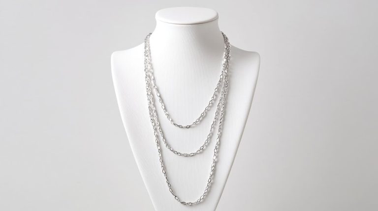 Layered silver necklaces of varying lengths displayed on a white bust, demonstrating a chic, multi-layered look.