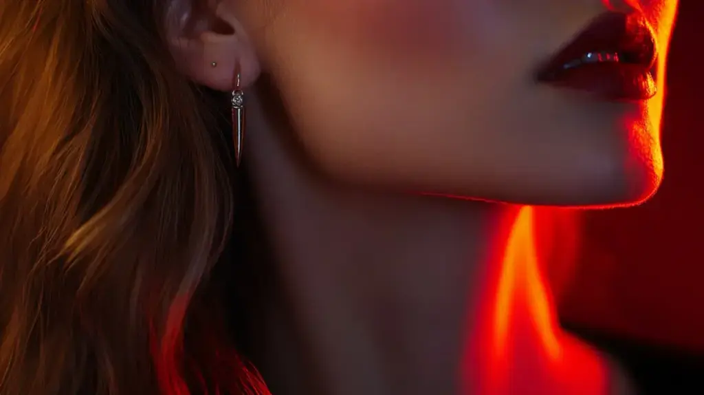 Elegant minimalist dagger earrings worn in a dramatic nighttime setting, reflecting a modern interpretation of dagger symbolism in jewelry.