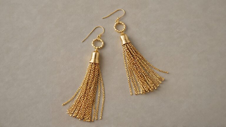 A pair of gold chain tassel earrings with delicate metal strands and hook fastenings, displayed on a neutral background, showcasing their elegant and luxurious design.