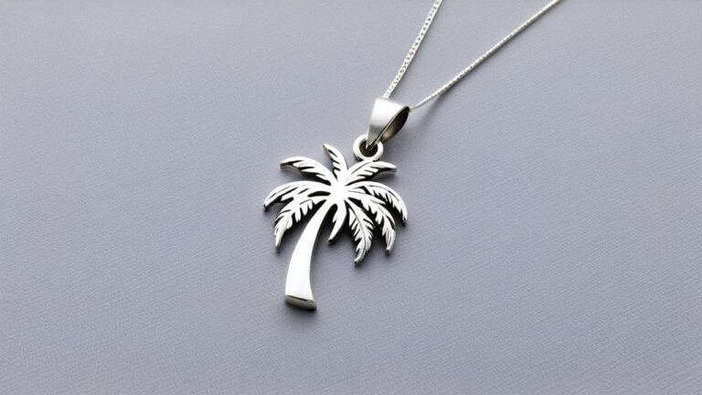 Sterling silver palm tree pendant with detailed fronds hanging from a delicate silver chain against a gray background.