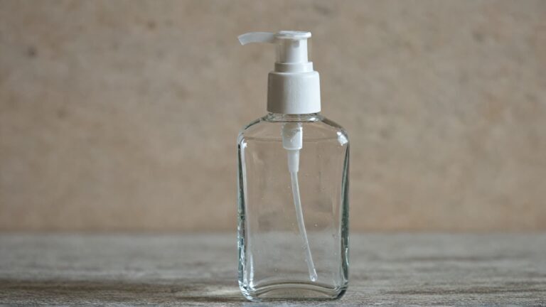 Glass hand sanitizer bottle with pump dispenser showing typical sanitizer container used daily that can affect jewelry and rings