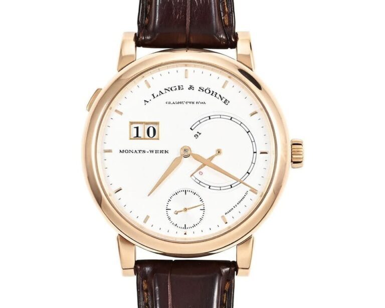 A. Lange & Söhne Lange 1 watch in rose gold case with white dial, featuring asymmetrical layout with oversized date at 12 o'clock, power reserve indicator, and subsidiary seconds on brown alligator leather strap