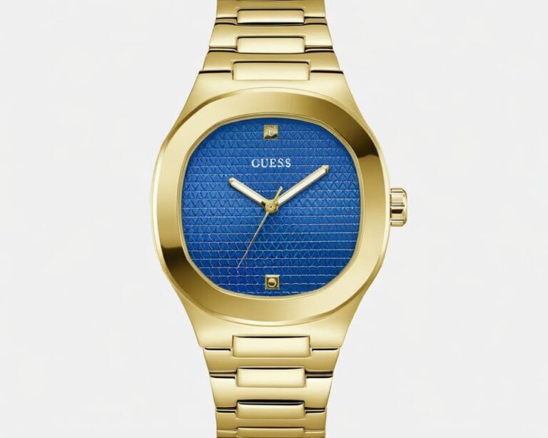 Guess watch with gold-tone cushion-shaped case, blue textured dial pattern, gold bracelet, and white hands showcasing luxury fashion timepiece design