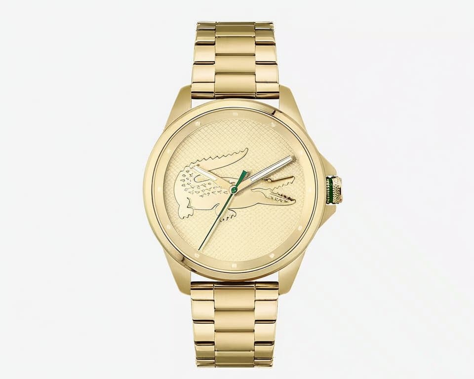 Lacoste gold-tone watch with oversized embossed crocodile logo on textured dial, matching gold steel bracelet and green accent hands
