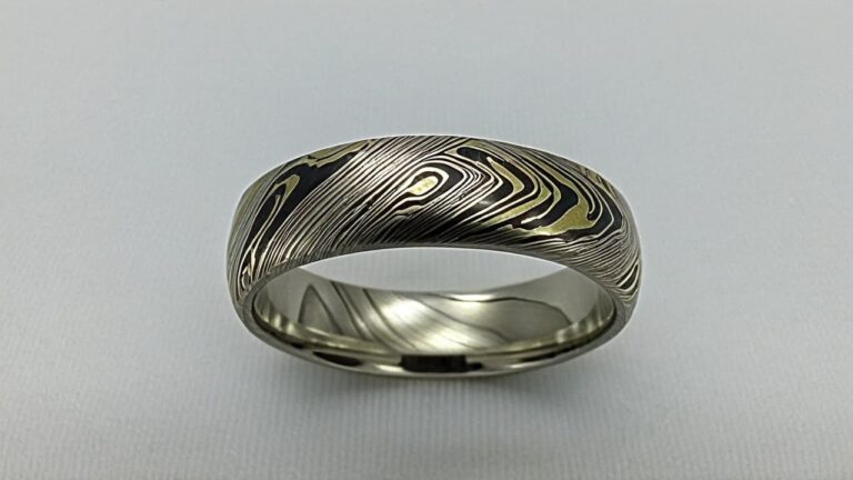 Shibuichi ring displaying characteristic gray patina with green and brown color variations from traditional Japanese metalworking
