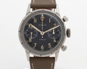 Vintage Dodane Type 21 French Air Force flyback chronograph showing aged luminous numerals, bi-compax dial layout, and brown leather strap